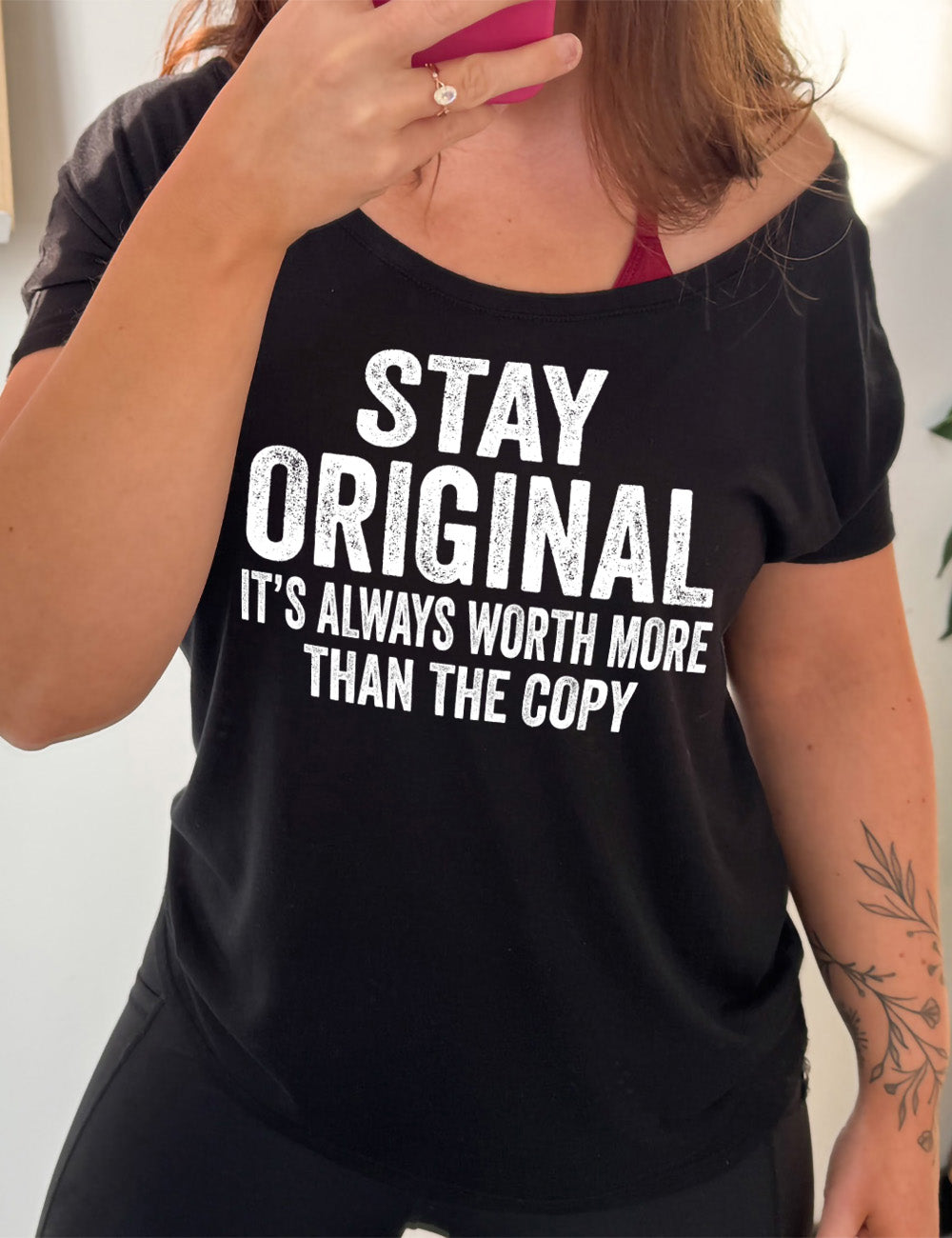 black slouchy tee with the large wording saying "stay original" followed by smaller wording saying "it's always worth more than the copy"