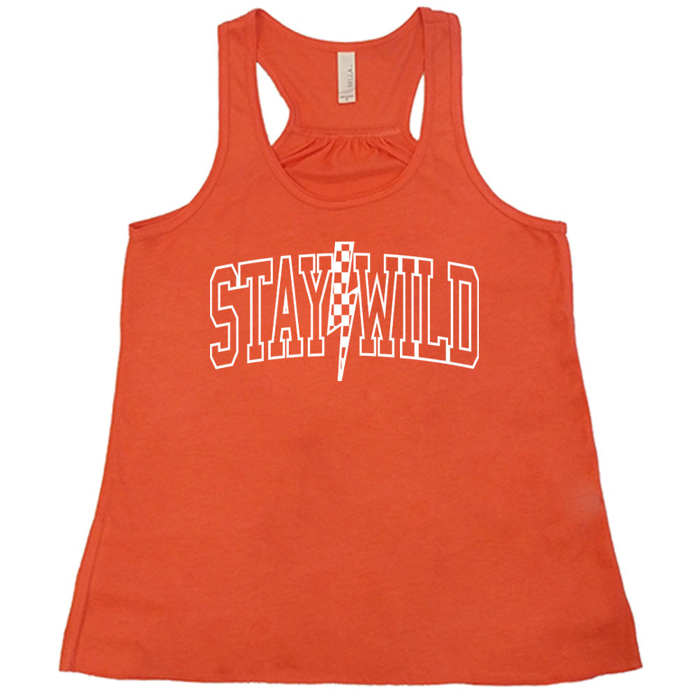 Coral colored flowy tank with a checkered lightning strike graphic on it that says "Stay Wild" 