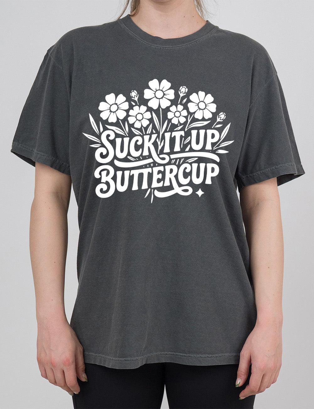 pepper modern tee with the words "suck it up buttercup" on it, with the graphic of a bouquet of flowers, the words in front of the stems