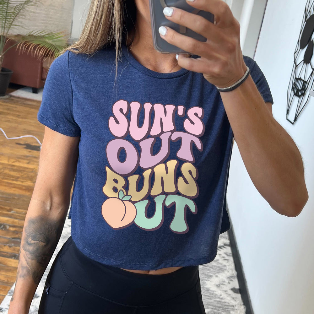 heather navy cropped tee with a peach graphic on it that says "Suns Out Buns Out" 
