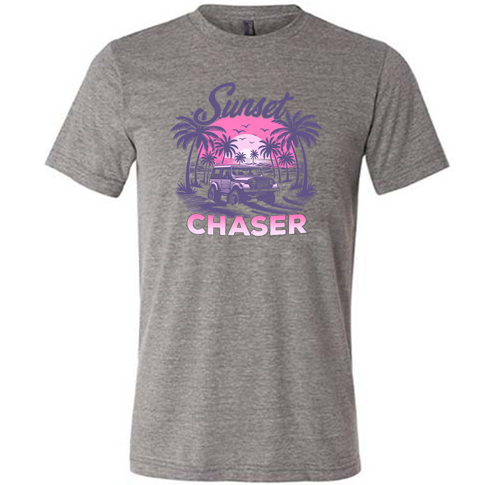 Grey colored shirt with a vehicle on the beach graphic on it that says "Sunset Chaser" 