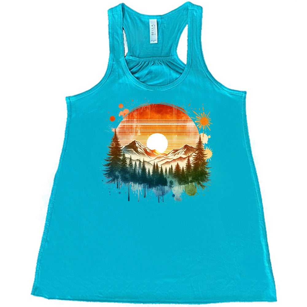 Teal colored flowy tank with a sunset-mountain landscape graphic on it