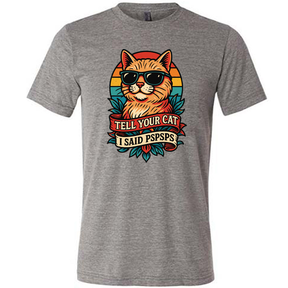 grey unisex tee with the large graphic of a cat head and torso, wearing sunglasses, with a colorful background, and two banners below it with the words "tell your cat I said pspsps" on them