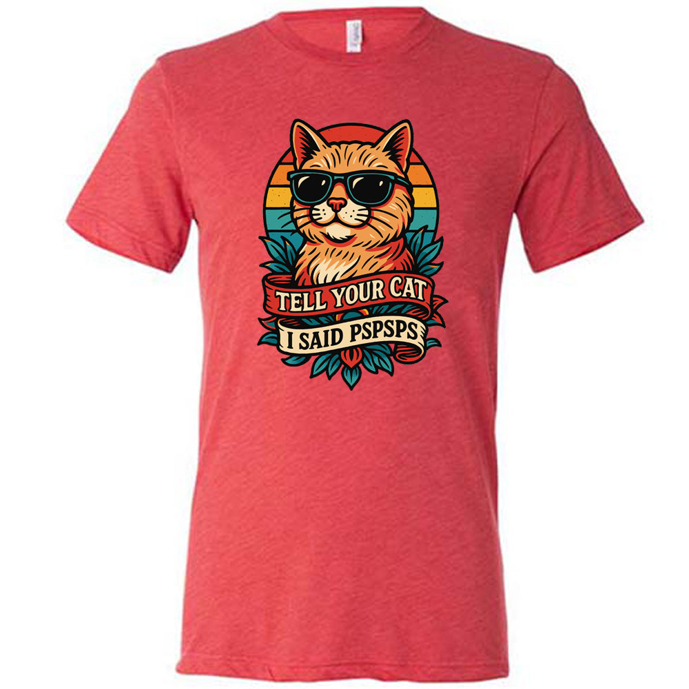 red unisex tee with the large graphic of a cat head and torso, wearing sunglasses, with a colorful background, and two banners below it with the words "tell your cat I said pspsps" on them