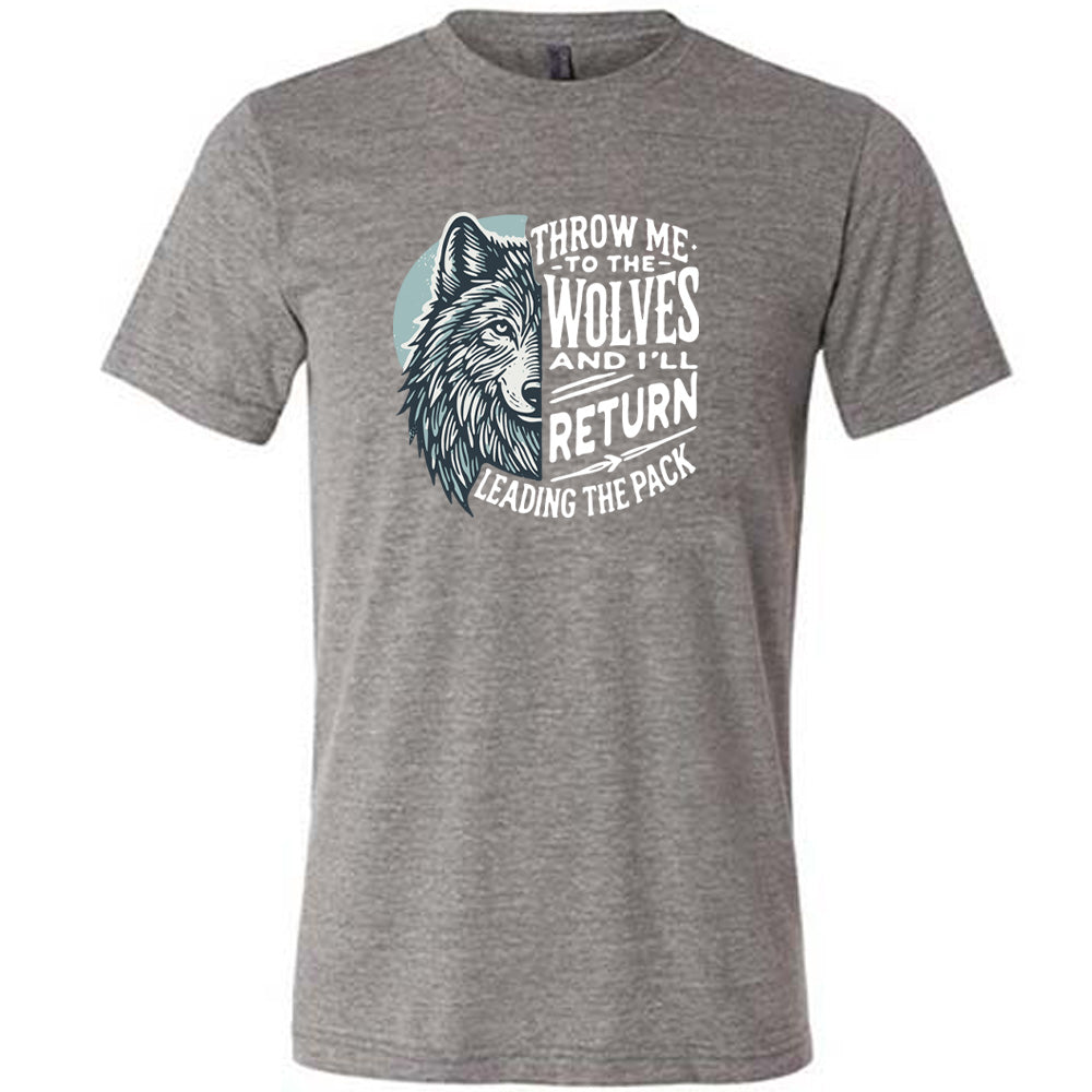 Grey colored shirt with a wolf face graphic on it that says "Throw Me To The Wolves And I'll Return Leading the Pack" 