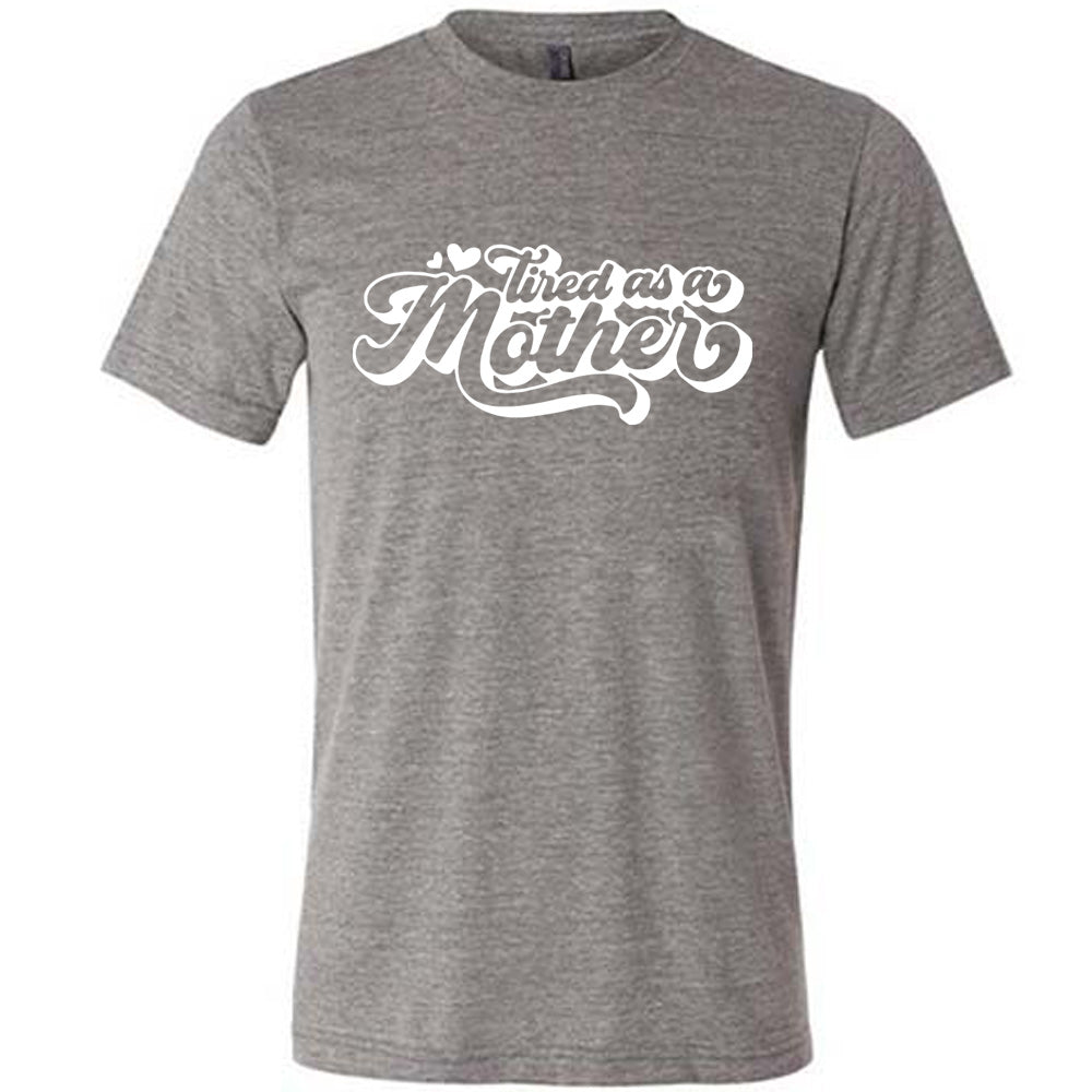 grey unisex tee with the words "tired as a mother' on it, with a couple little hearts at the start