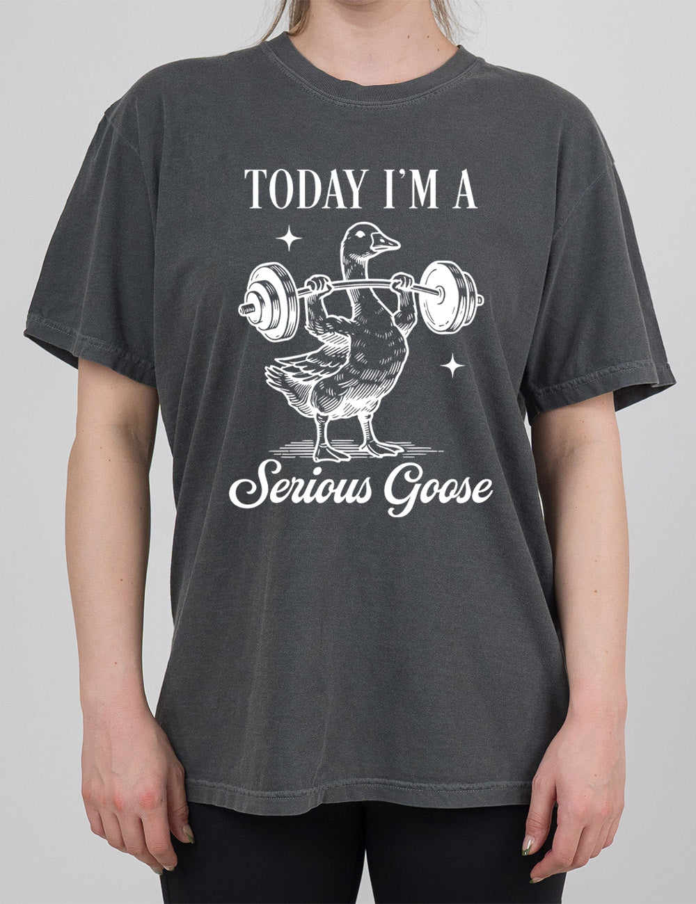 pepper modern tee with the graphic of a goose lifting a barbell (with arms), and the words around this image saying "today I'm a serious goose"