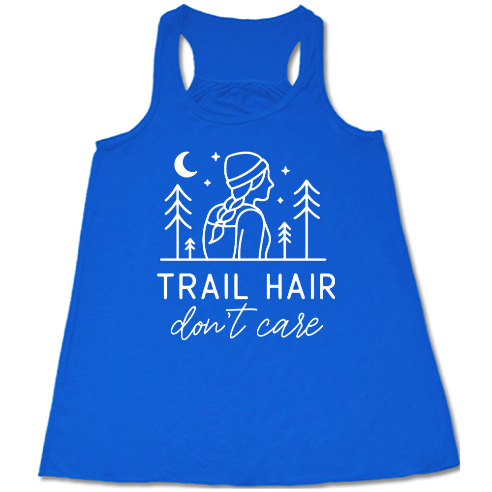 blue flowy tank with the words "trail hair don't care" on it, under the line art graphic of a woman with a hat and braided hair, the moon and stars, and four trees