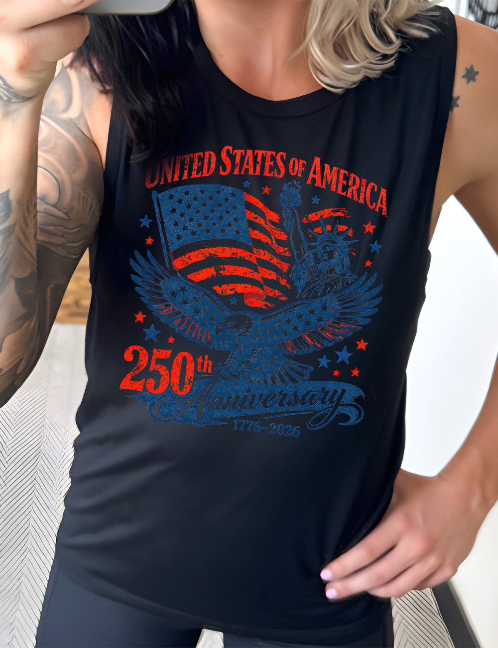 black muscle tank with the graphic of the eagle, wings spread, the statue of liberty, and an American flag, and lots of little stars, and the words saying "United Stated of America 250th Anniversary 1776-2026"