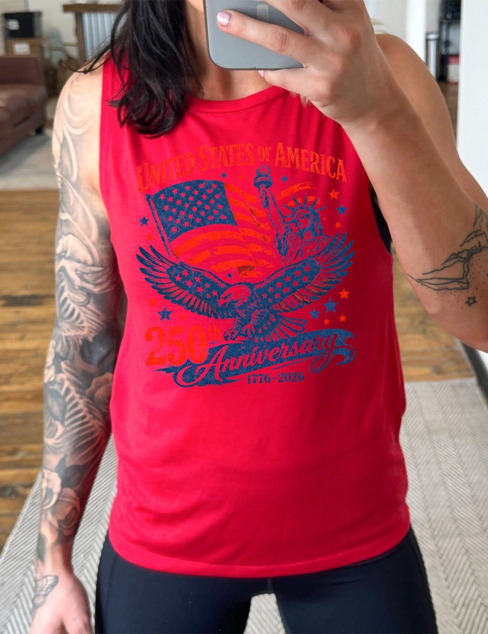 red muscle tank with the graphic of the eagle, wings spread, the statue of liberty, and an American flag, and lots of little stars, and the words saying "United Stated of America 250th Anniversary 1776-2026"