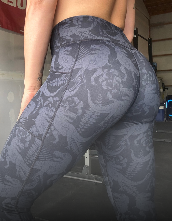 Person wearing dark gray leggings with a pattern, standing in a garage.