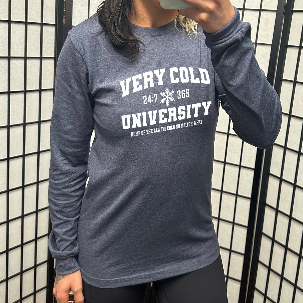 heather navy long sleeve shirt with the words "very cold university" in big letters, with 24:7 and 365 separated by a snowflake graphic, and little words underneath it all saying "home of the always cold no matter what"