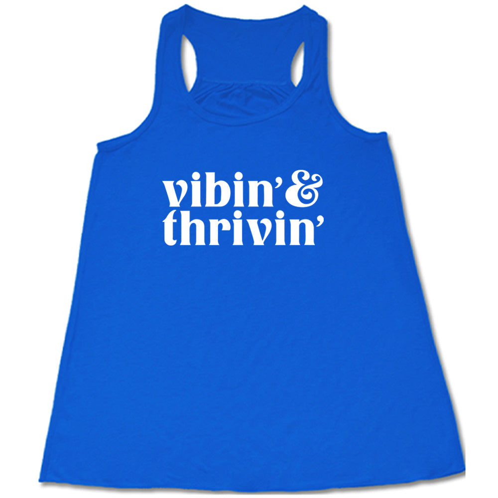 blue shirt with the text "Vibin & Thrivin" on it