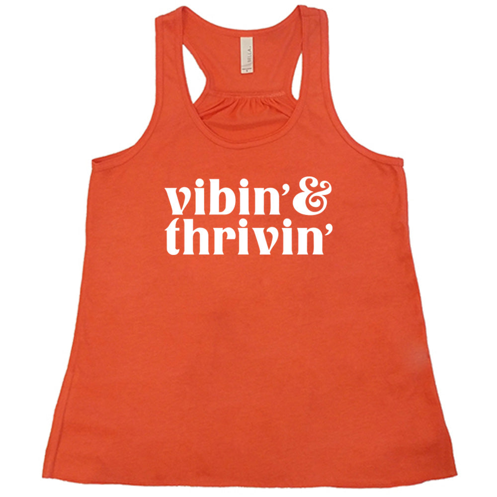 coral shirt with the text "Vibin & Thrivin" on it