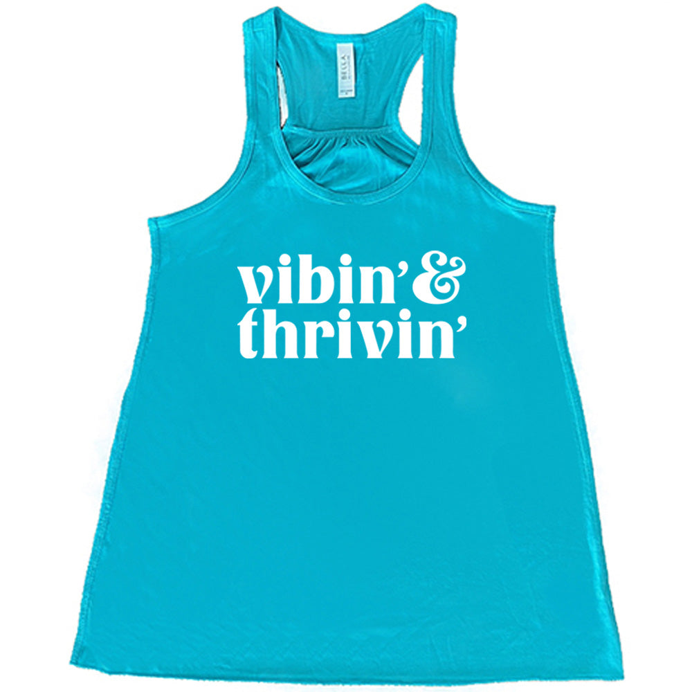 teal shirt with the text "Vibin & Thrivin" on it