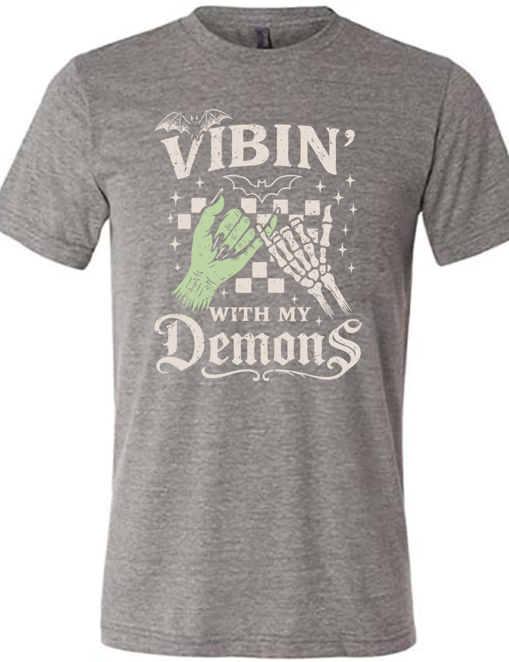 grey unisex tee with words saying "Vibin' with my Demons", around the graphic of the hands of a zombie and a skeleton doing a pinky promise, in front of a checkered background, and one line-drawn bat and one detailed bat on top, and scattered stars