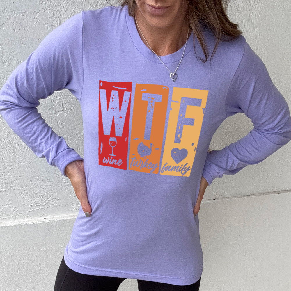 heather dark lavender long sleeve shirt with a graphic on it that says "WTF" and under the "W" there's a graphic of a wine glass and the word "wine"; under "T" there's a graphic of a turkey and the word "turkey"; under F there's a graphic of a heart and the word "family"
