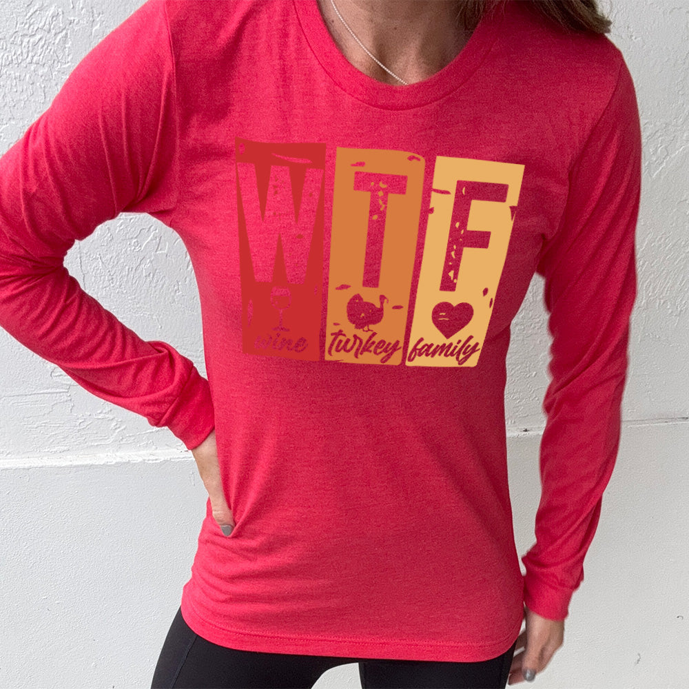 heather red long sleeve shirt with a graphic on it that says "WTF" and under the "W" there's a graphic of a wine glass and the word "wine"; under "T" there's a graphic of a turkey and the word "turkey"; under F there's a graphic of a heart and the word "family"