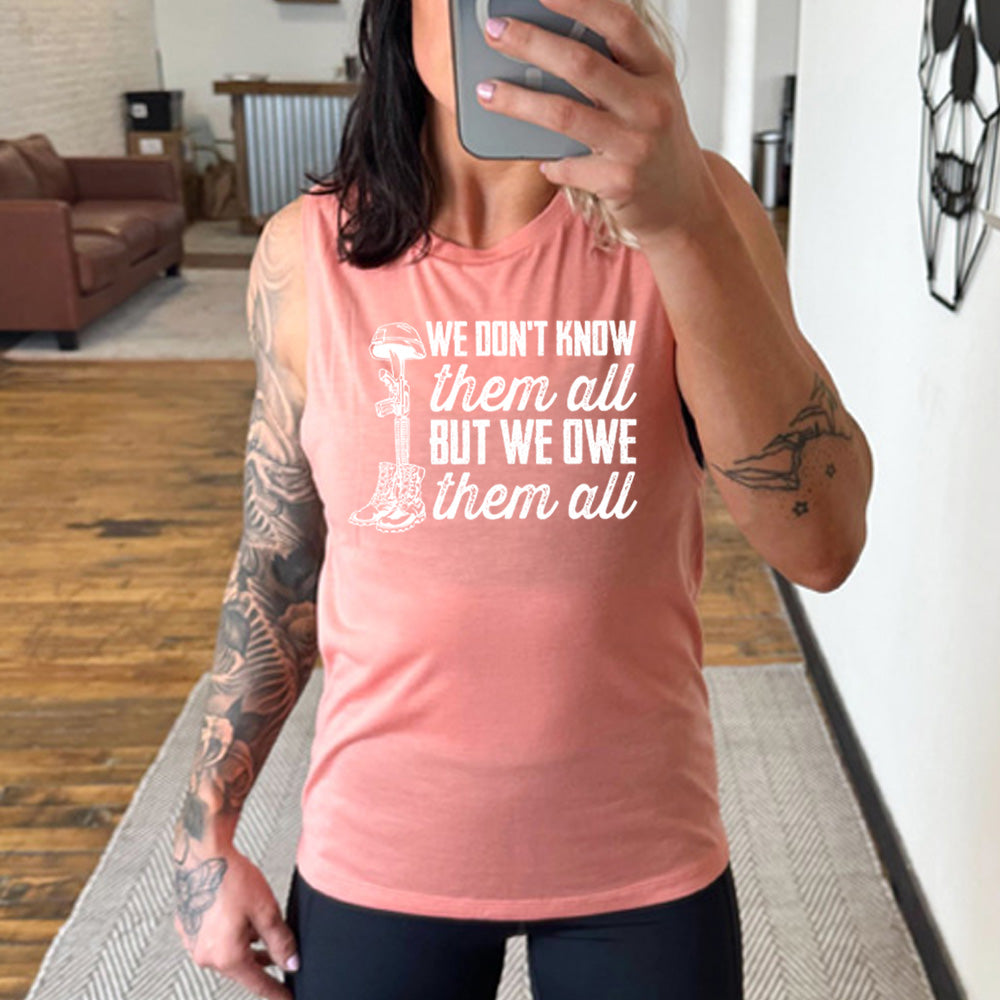 model wearing the peach "We Don't Know Them All But We Owe Them All" Muscle Tank