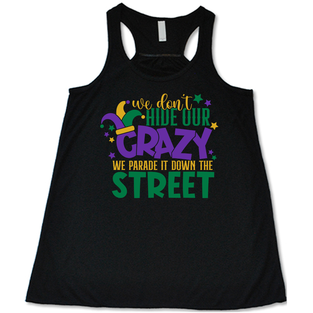 black flowy tank with the words "we don't hide our crazy we parade it down the street" on it with a joker hat on the letter "c" and a few little stars scattered around