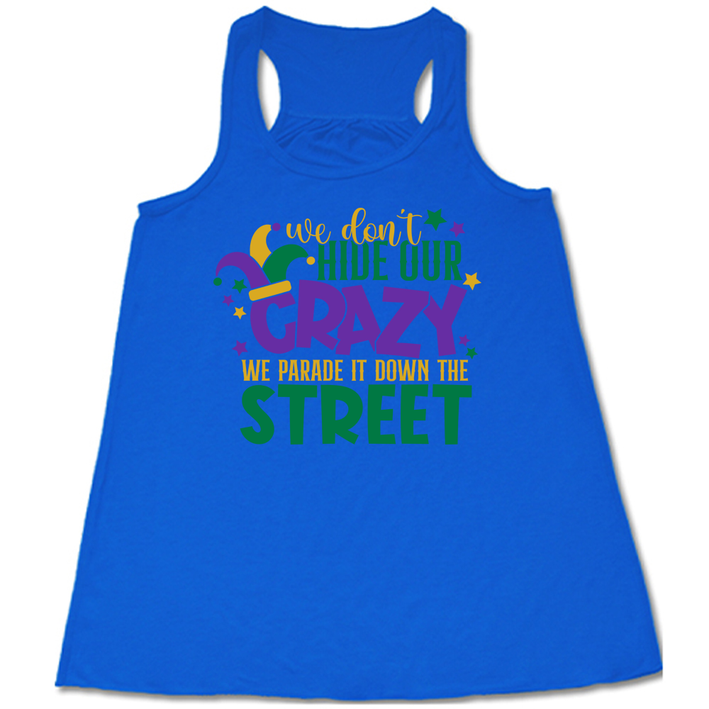 blue flowy tank with the words "we don't hide our crazy we parade it down the street" on it with a joker hat on the letter "c" and a few little stars scattered around