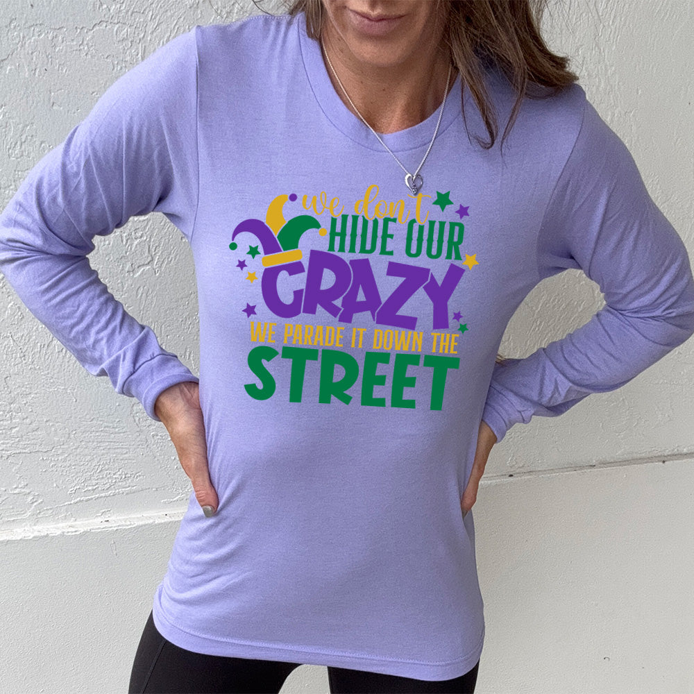 heather dark lavender long sleeve tee with the words "we don't hide our crazy we parade it down the street" on it with a joker hat on the letter "c" and a few little stars scattered around