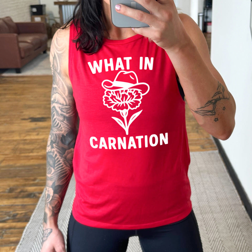 red muscle tank with the words "What in carnation" on it, around the graphic of a carnation, wearing a cowboy hat