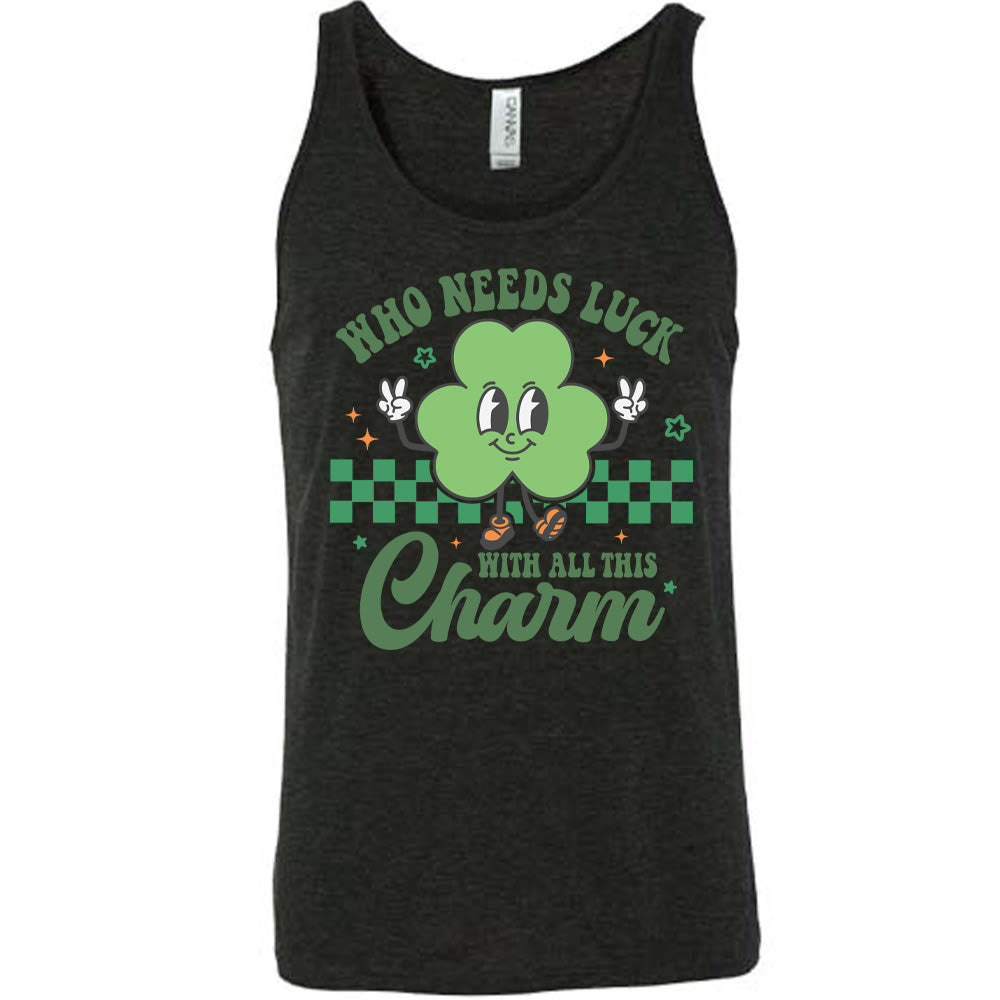 black unisex tank with the words "who needs luck with all this charm" on it, with the graphic of a cheerful shamrock (with eyes, nose and smiling mouth) giving two peace signs with its hands, in front of a partial checkered background, with a few stars around