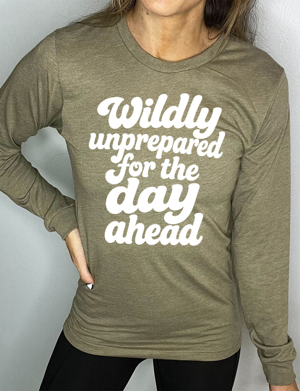 heather olive long sleeve tee with words on it saying "Wildly unprepared for the day ahead"