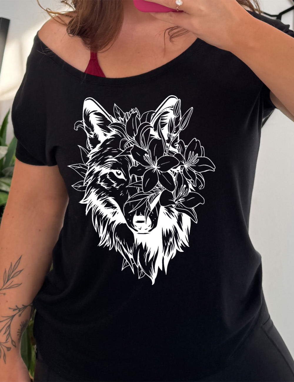 black slouchy tee with the large graphic of a wolf's head, with lilies covering half of the face, and growing behind its head too