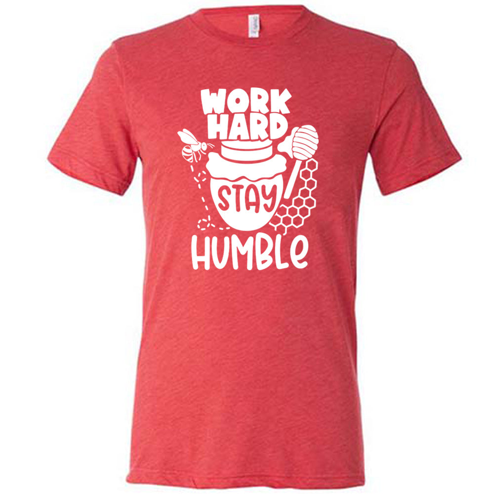 red unisex tee with the words "work hard stay humble" on it, with the word "stay" on the graphic of a honeypot, and a bee flying around the pot's left, and some honeycomb and a honey spoon on its right