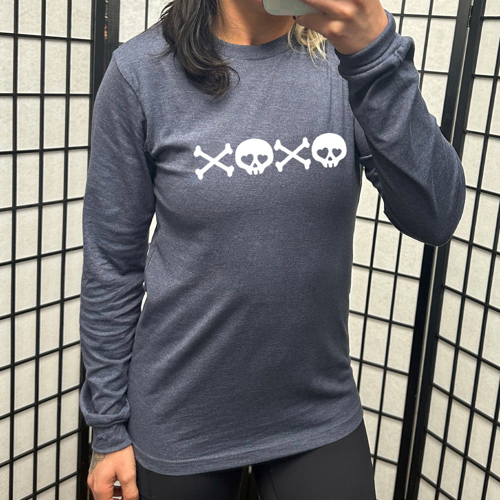heather navy long sleeve shirt with graphics of crossed-bones and skulls (with hearts for eyes) forming the phrase "XOXO"