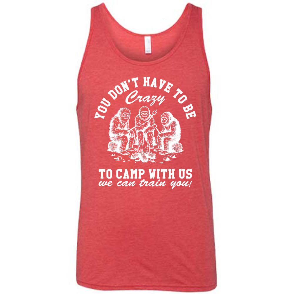 red unisex tank with the words "you don't have to be crazy to camp with us we can train you!" on it with the graphic of three sasquatches toasting marshmallows over a campfire