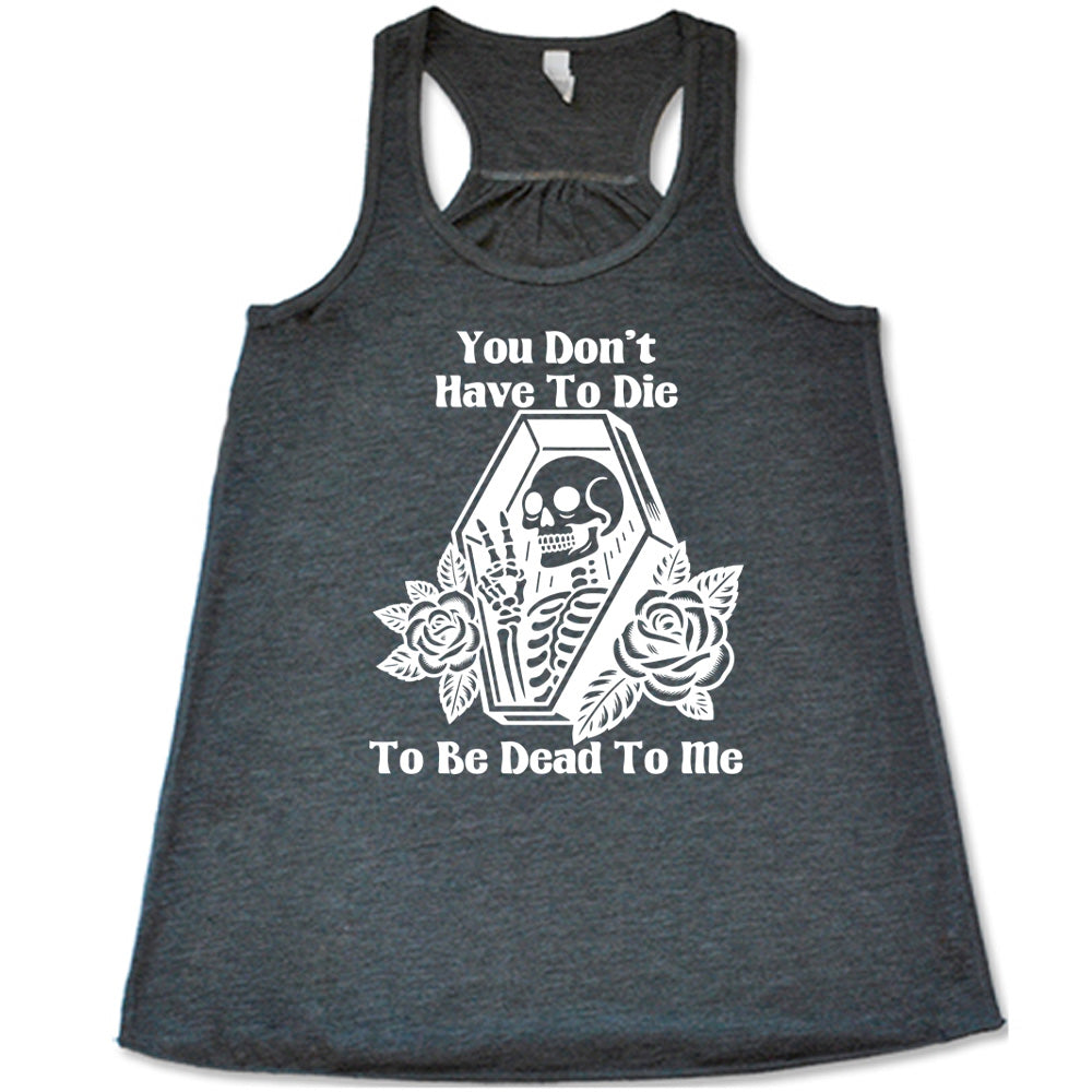 grey flowy tank with the words "You don't have to die to be dead to me" on it with the graphic of a a skeleton in a coffin, giving the peace sign, with two flowers on either side of the coffin