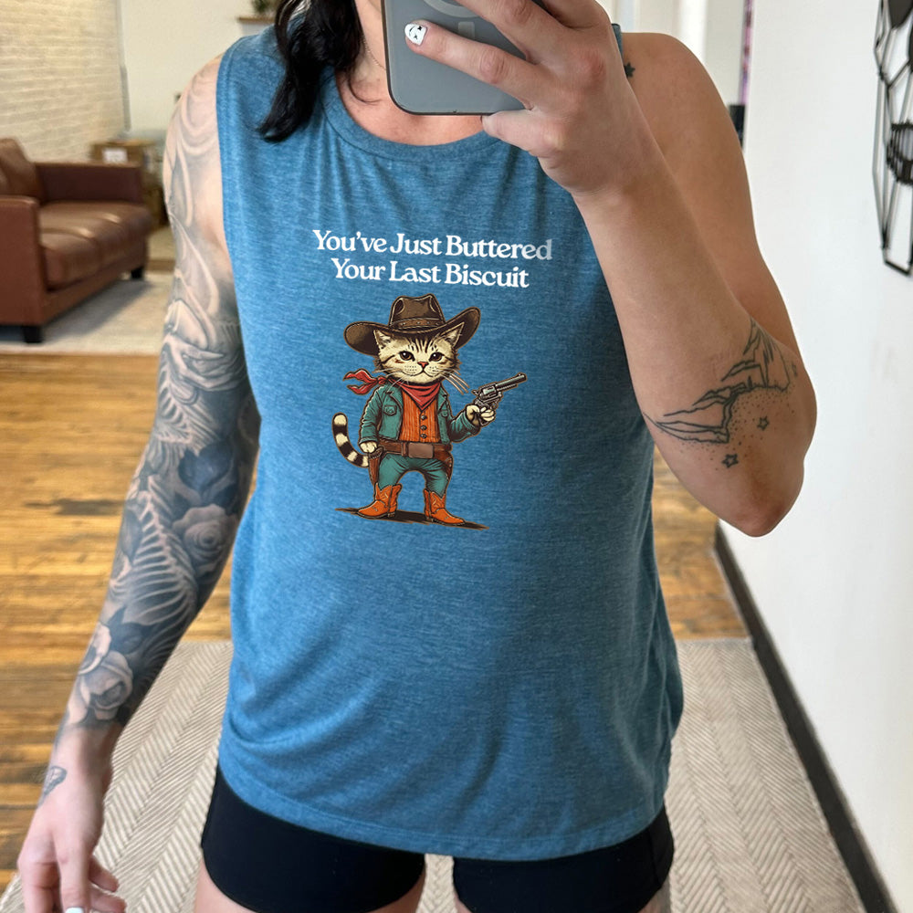 deep teal muscle tank with a cat wearing cowboy gear graphic on it that says "You've Just Buttered Your Last Biscuit"