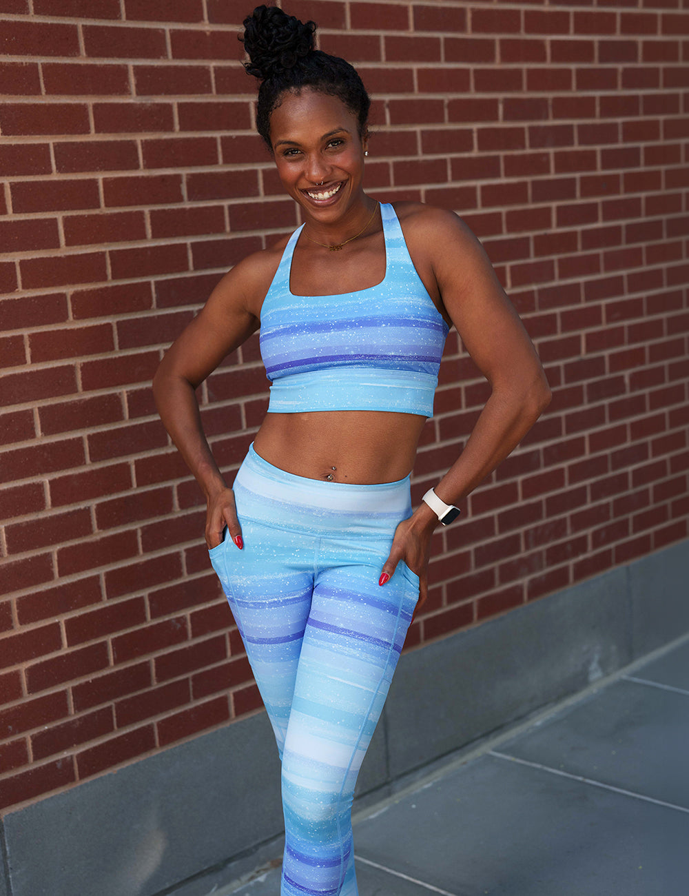 model wearing the blue and white ombre leggings in front of a brick wall