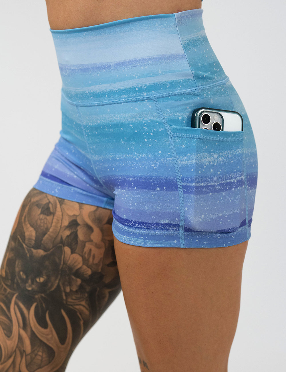 close up of the 2.5 inch blue and white ombre shorts with a phone in the pocket