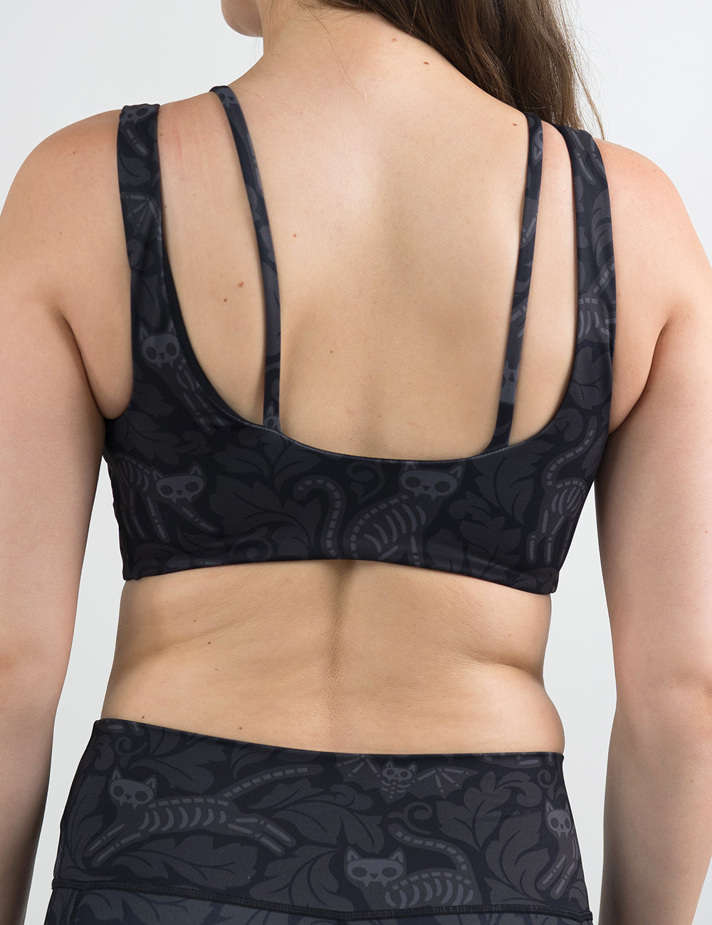back of the black and grey bats and cats skeleton bra against a white background