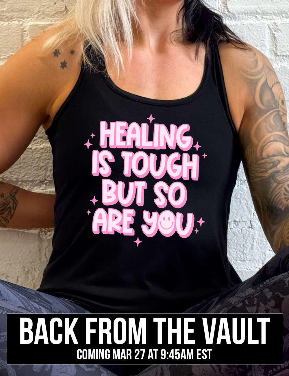 black racerback flowy tank with the words "healing is tough but so are you" on it, with a smiley face in the word "you", and little star graphics scattered around, coming soon