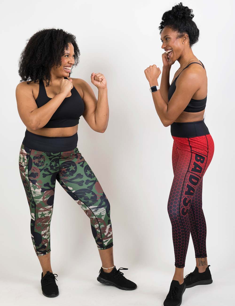 Two models in boxing position wearing camo leggings with skulls and the other in red leggings with the word "badass"