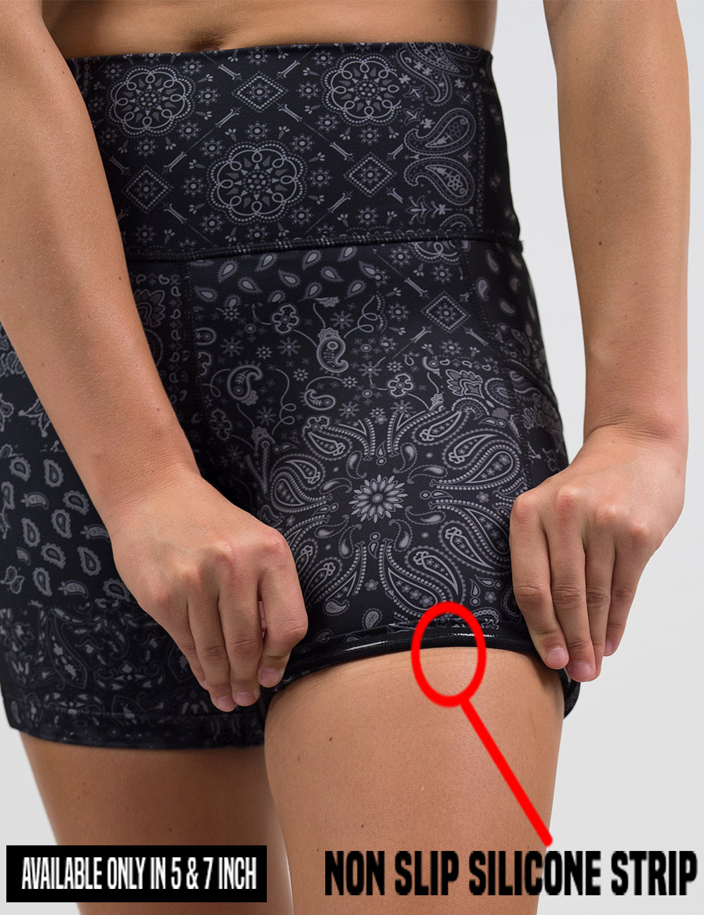 close up of the black shorts with a white paisley pattern being rolled up to show the non slip silicone strip found in the 5 and 7 inch shorts