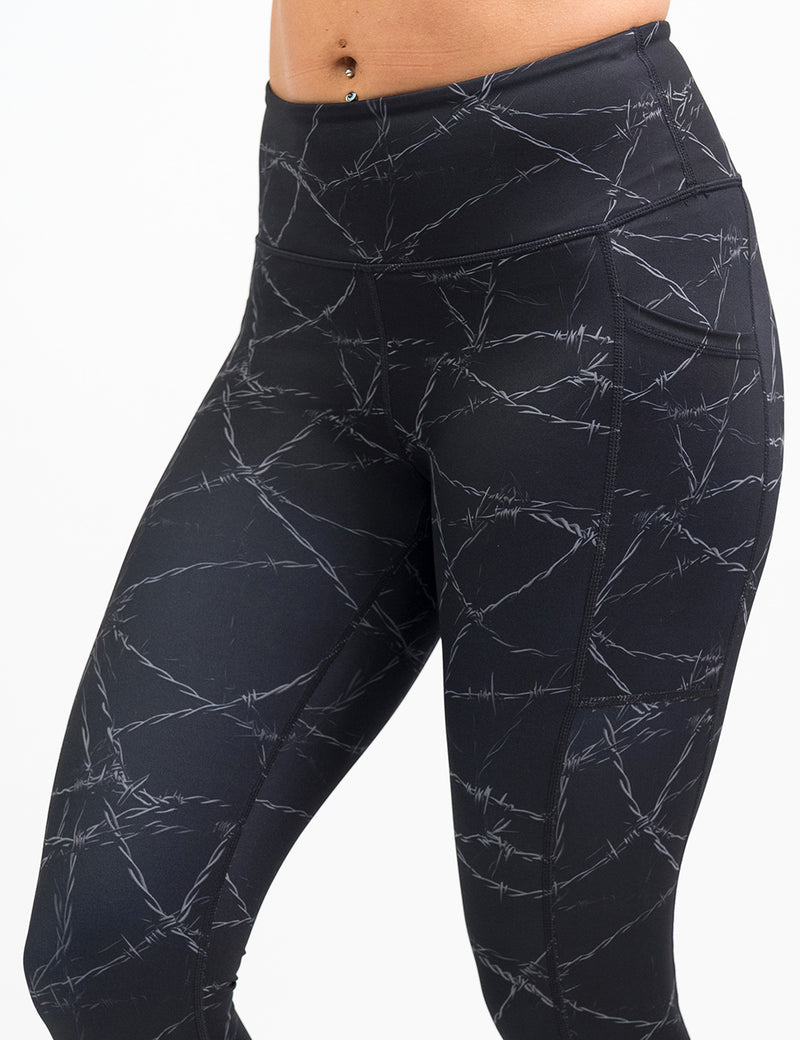 black leggings with a white barbed wire pattern on it against a white background