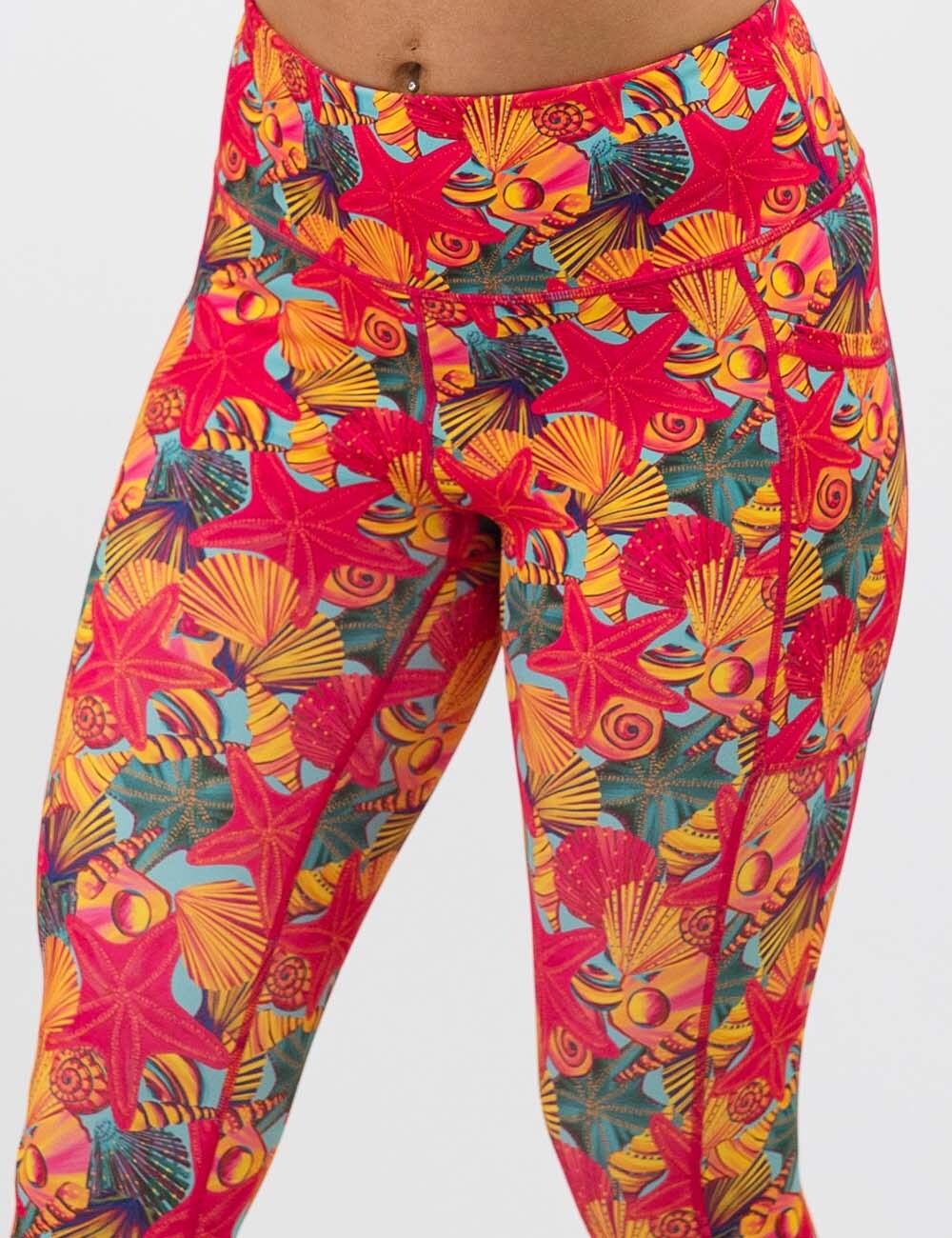 front of the red starfish with a yellow and blue shell background leggings against a white background