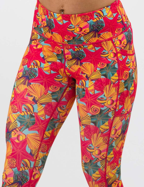 front of the red starfish with a yellow and blue shell background leggings against a white background