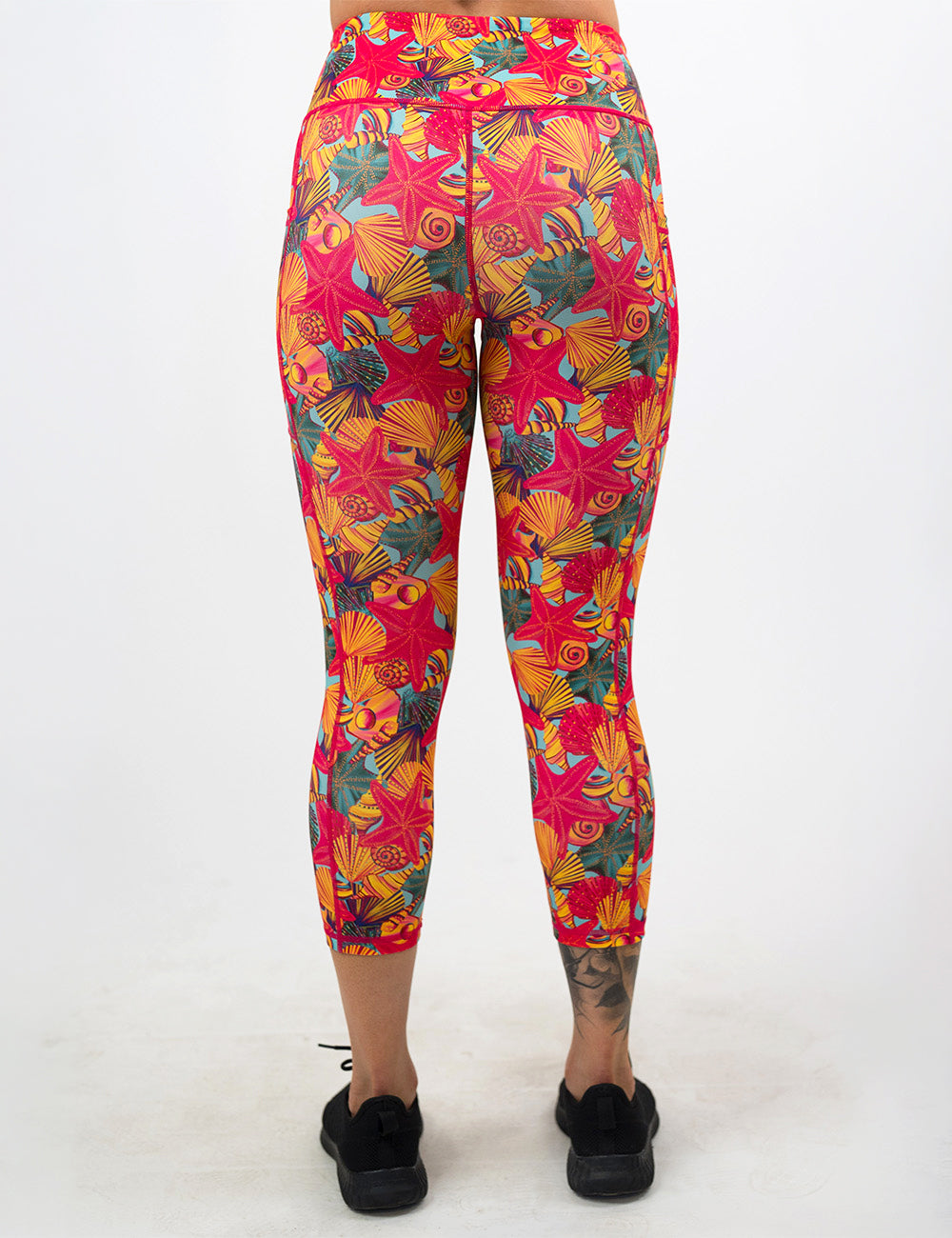 back of the front of the red starfish with a yellow and blue shell background capri leggings against a white background