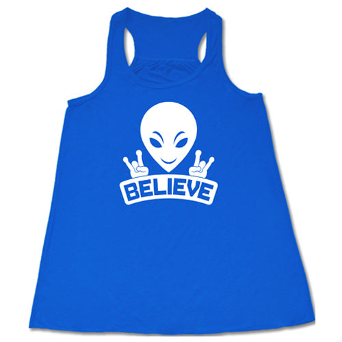 blue racerback tank top that has an alien design on it that says "believe"