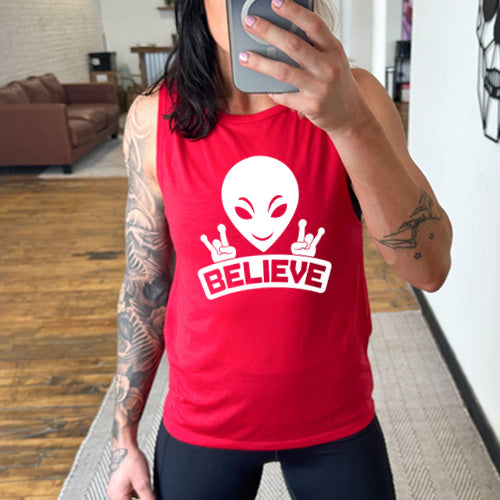 red muscle tank top that has an alien design on it that says "believe"
