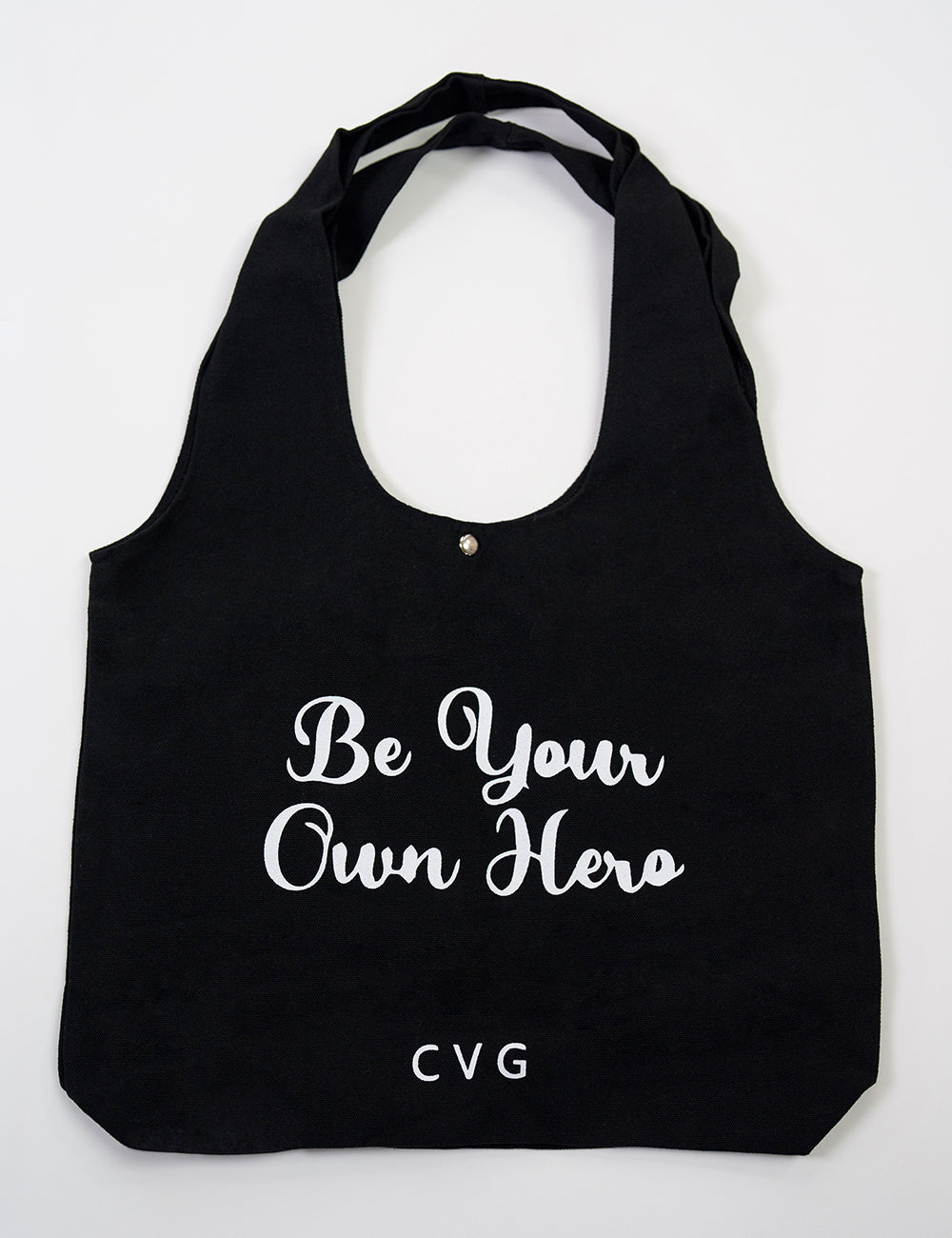 Black tote bag with the CVG logo and the large words "be your own hero" on it
