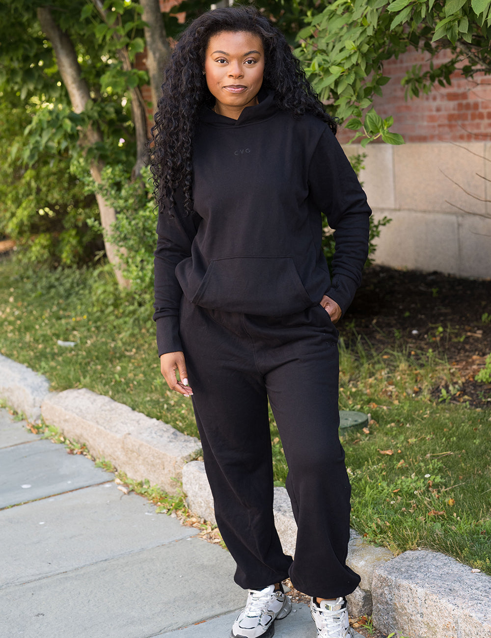 model wearing the black sweatsuit with subtle CVG logos