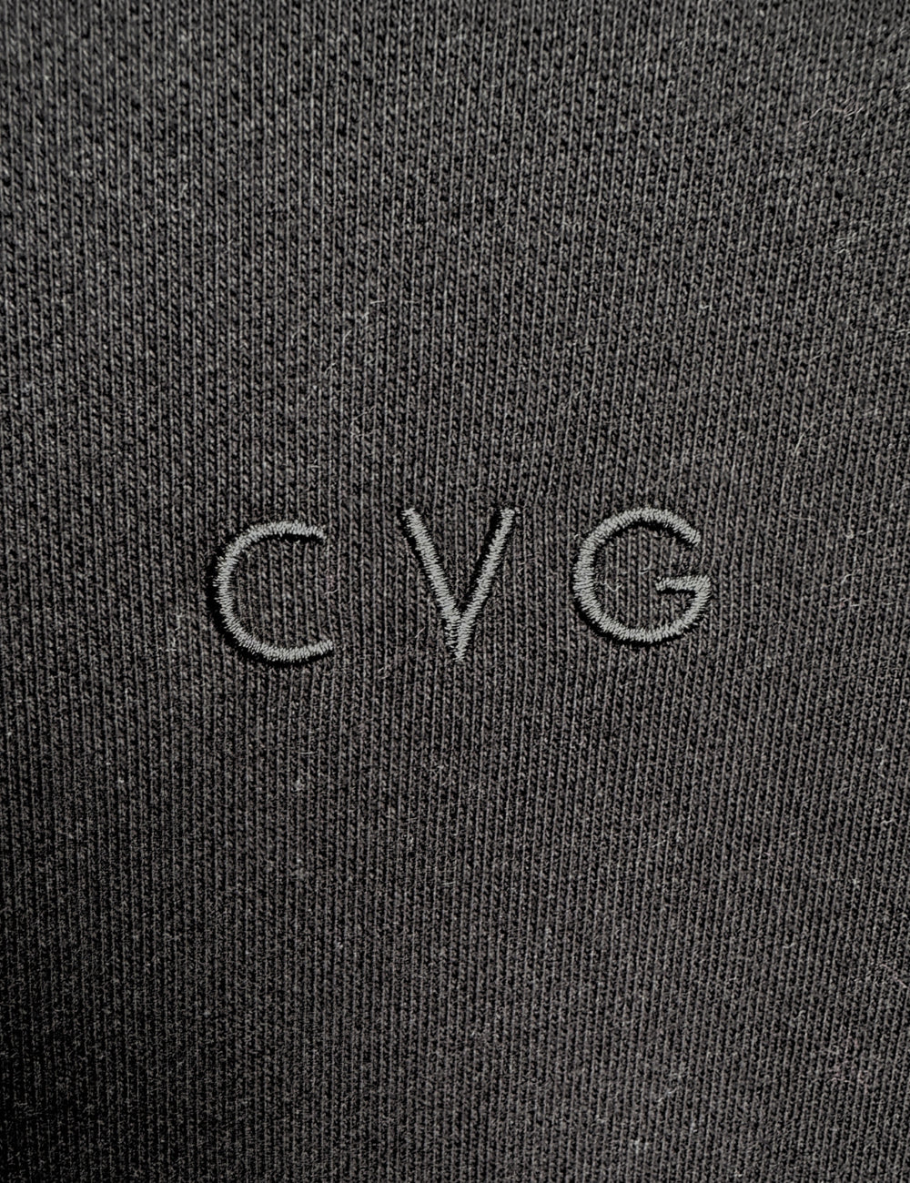 close up of the subtle CVG logo found on the black unwind hoodies and sweatpants